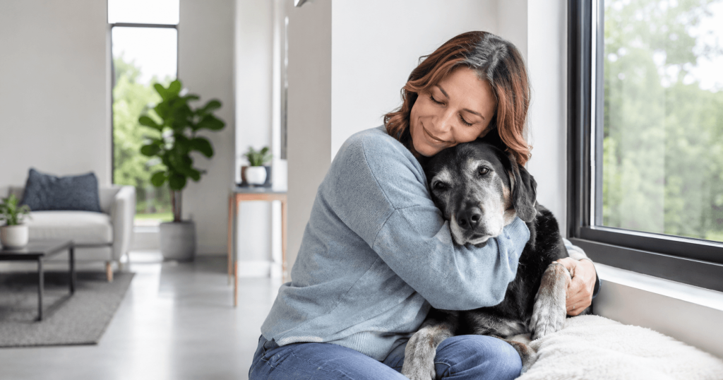 Woman lovingly embracing her adopted senior dog showing the bond that pet adoption creates